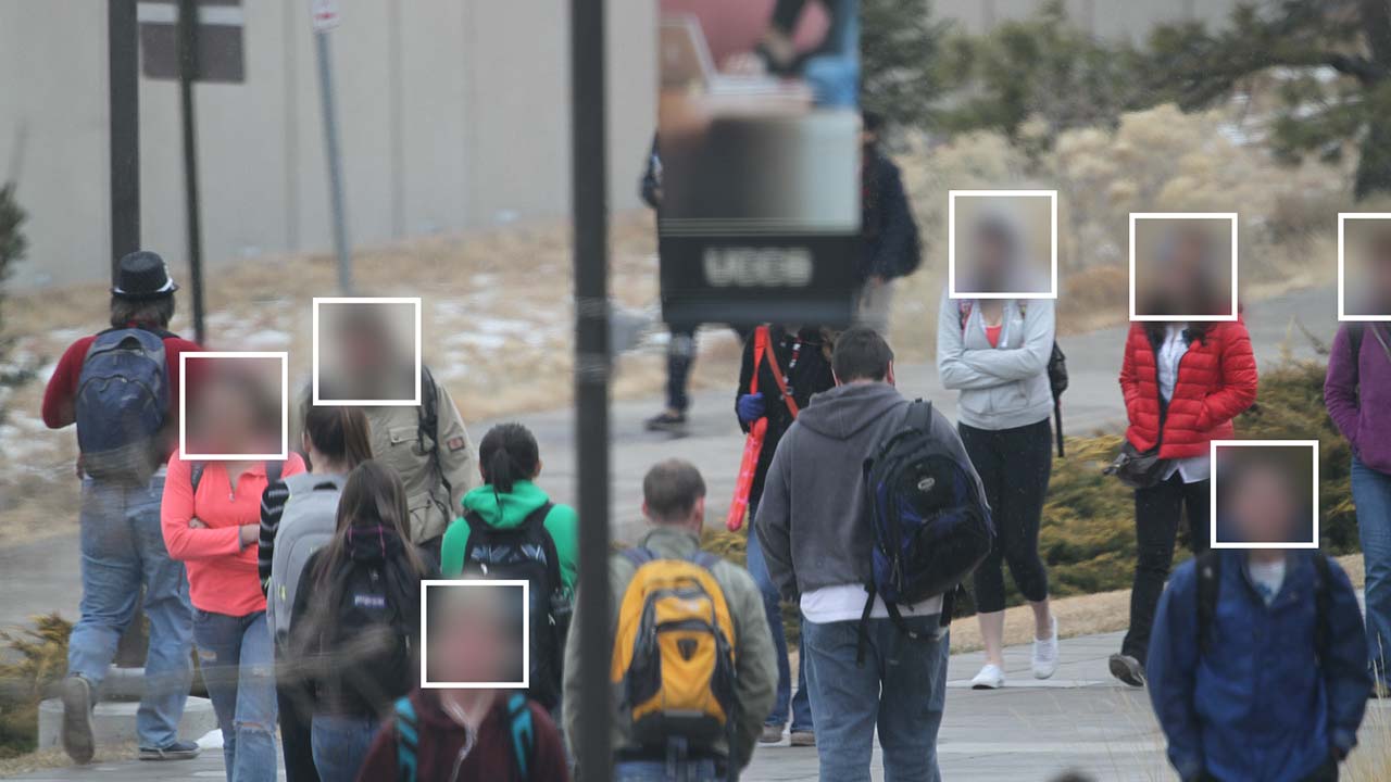 An image of students in the UCCS dataset that was surreptitiously photographed with a long-range camera for use in facial recognition experiments. Faces are redacted for privacy.